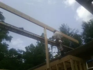 Carpenter setting a ridge beam over a new addition frame — Ice Dam Removal by Roofing Brothers in Medway
